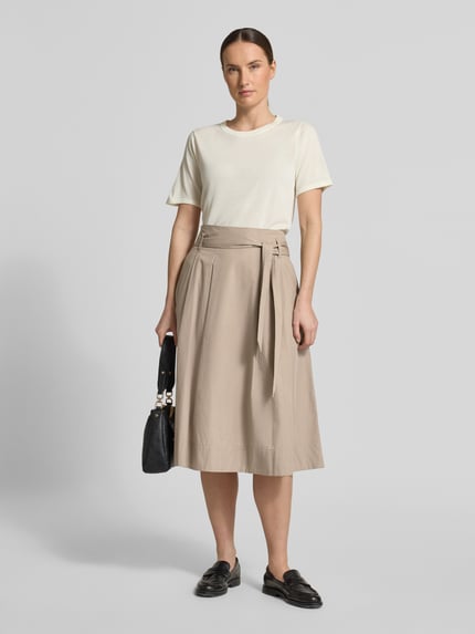 Frauenmodel trägt Regular Fit Midirock in Falten-Optik von Christian Berg Woman aus Reine Baumwolle in Beige, Ganzkörperansicht von vorne. Bundweite 37 cm, Gesamtlänge 74 cm, mit Reißverschluss und abnehmbarem Stoffband.