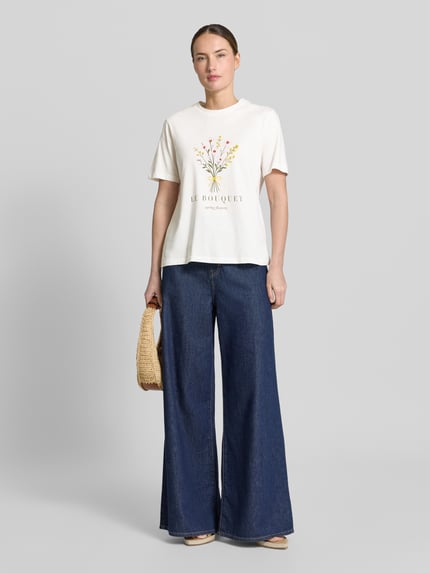 Frauenmodel trägt Damen T-Shirt mit Motiv-Print Modell 'SYBIL' von Vila, cremefarben, Reine Baumwolle, Gerader-Schnitt, Rundhalsausschnitt, Ganzkörperansicht von vorne.