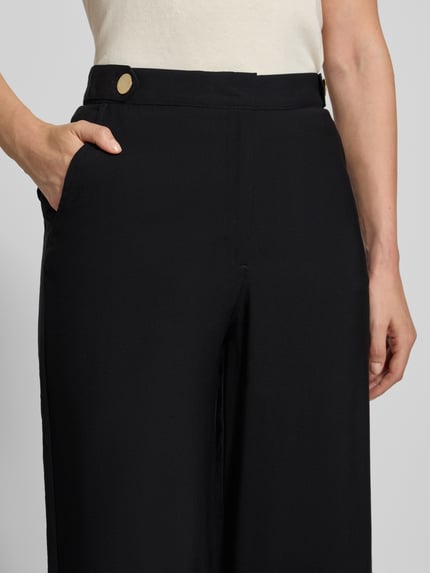 Frauenmodel trägt schwarze Weite Hose mit Modal-Mix von Jake*s Casual, glatte Struktur, goldener Knopf, Nahaufnahme Oberkörper.