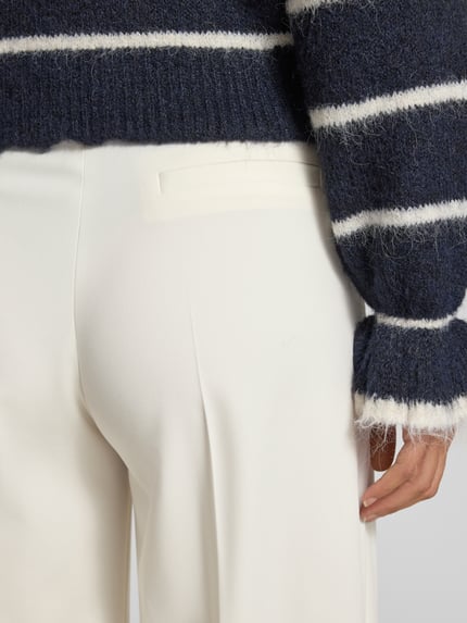 Vrouwenmodel draagt Regular Fit wijdte dames broek met Viskose-Anteil model 'HUZILI' van HUGO, look: effen, materiaalverwerking: twill, materiaalmix met viscose, detailopname rugzijde.