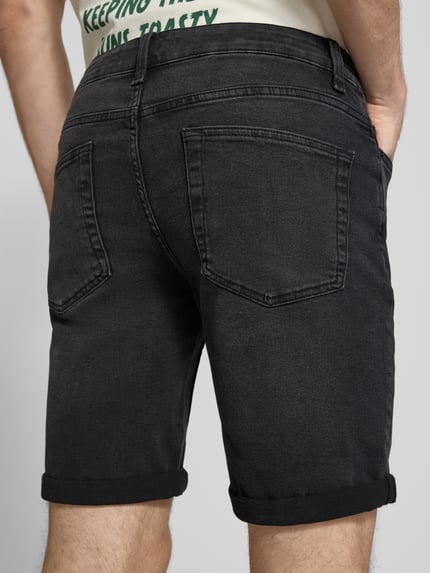 Männermodel trägt Regular Fit Jeansshorts aus Baumwoll-Mix mit Viskose-Anteil Modell 'SPY' von Only & Sons, Denim-Optik, schwarze Farbe, Twill-Materialverarbeitung, Label-Patch, 5-Pocket-Design, Knopf und verdeckter Reißverschluss, Ganzkörperansicht Rückansicht.