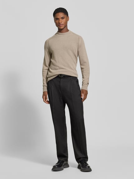 Männermodel trägt Regular Fit Pullover aus Viskose-Woll-Mix Modell 'Wylandor' von JOOP! COLLECTION in Beige mit glatter Textur, Ganzkörperansicht von vorne.