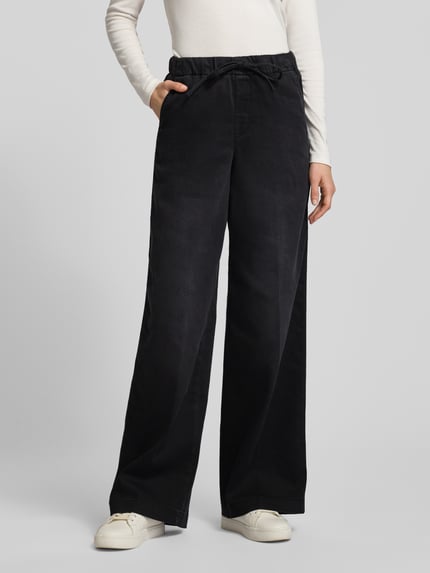 Frauenmodel trägt schwarze Jeans mit elastischem Bund von MAC aus Baumwoll-Mix, locker geschnitten, mit Tunnelzug und Taschen, Ganzkörperansicht von vorne.