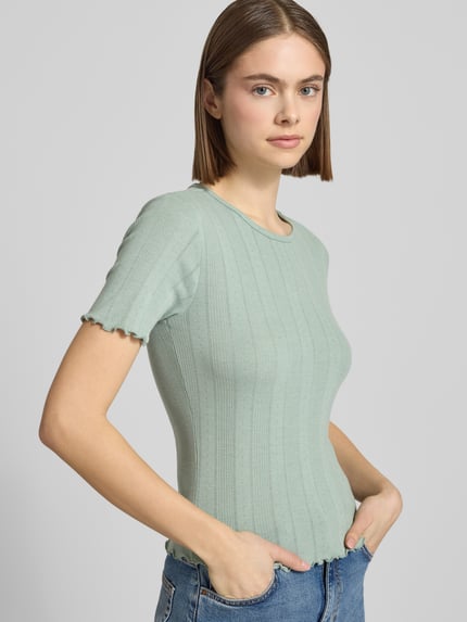 Vrouwenmodel draagt slim fit T-shirt uit katoenmix model 'TENNA' van Only in look: effen met ronde hals, korte mouwen, frill details; zijaanzicht, detailopname bovenlichaam