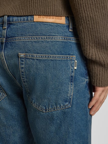 Männermodel draagt Jeans met 5-pocket-design model 'Doc' van WOODBIRD, pure katoen, rechte pasvorm, detailopname achterkant.