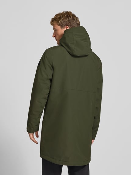 Męski model nosi oliwkowozieloną parkę Regular Fit z kapturem Didriksons, Model 'Kenny', wpuszczane kieszenie, długość tyłu 99 cm, szerokość ramion w rozmiarze M 48 cm, szerokość klatki piersiowej w rozmiarze M 59 cm, długość rękawów w rozmiarze M 72 cm, zdjęcie całej sylwetki z tyłu.