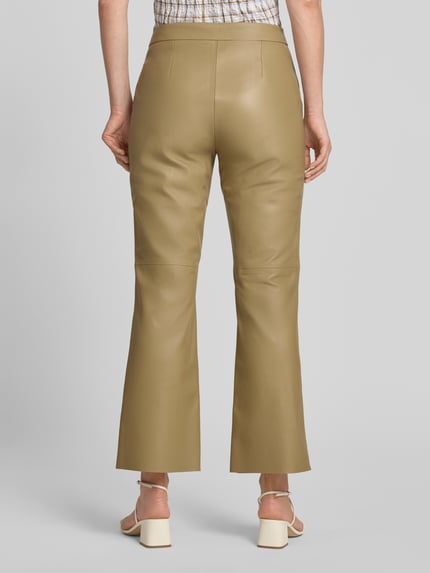 Vrouwenmodel draagt Regular Fit Lederhose aus echtem Lammleder model 'SIMARY' van BOSS in beige, glad oppervlak, dames, volledig lichaam achteraanzicht.