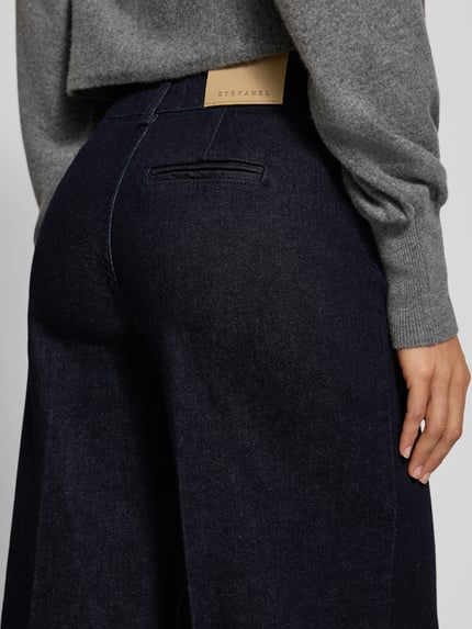 Frauenmodel trägt Wide Leg Jeans mit aufgesetzten Taschen von Stefanel, dunkler Baumwoll-Elasthan-Mix, Detailaufnahme Rückansicht.