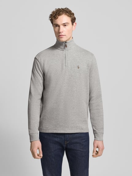 Männermodel trägt Sweatshirt mit Stehkragen von Polo Ralph Lauren, Reine Baumwolle, Regular-Fit, kurzer Reißverschluss, Label-Stitching, Grauton, glatte Textur, Rückenlänge 71 cm, Ärmellänge 65 cm, Ganzkörperansicht von vorne.