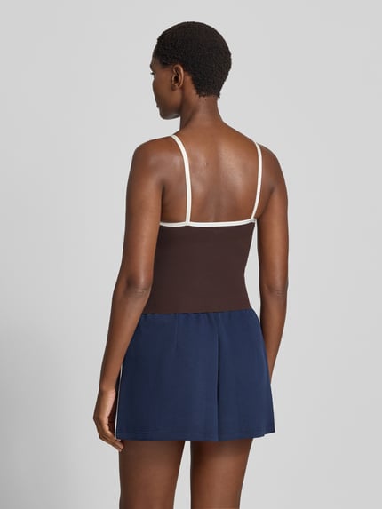 Frauenmodel trägt Trägertop mit Kontraststreifen Modell 'Sense Contour' von aim'n in Braun mit weißen Spaghettiträgern, Mix mit Stretch-Anteil, körpernahe Passform, Rückenlänge bei Größe S 22 cm, Ganzkörperansicht Rückansicht.
