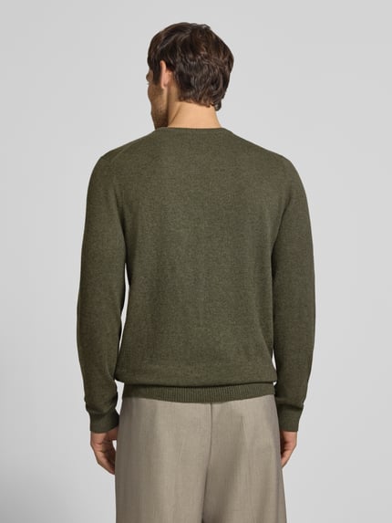 Männermodel trägt Kaschmirpullover mit gerippten Abschlüssen von Christian Berg Men in Olivgrün, gerade Form, Ganzkörperansicht Rückansicht. Reines Kaschmir mit Rundhalsausschnitt, klassische Strickstruktur, Rückenlänge 72 cm, Ärmellänge 72 cm.