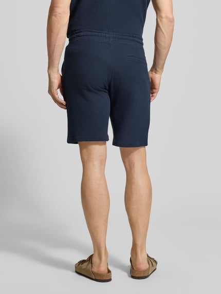 Männermodel trägt Sweatshorts mit elastischem Bund von MCNEAL aus Elastischer-Material-Mix, Strukturmuster, Gerade Passform, Ganzkörperansicht Rückansicht.