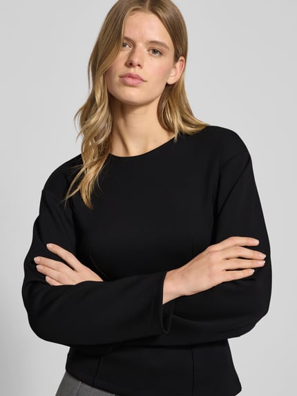 Frauenmodel trägt Shaped Fit Langarmshirt mit Viskose-Anteil Modell 'TOC' von Only in Schwarz, Kimonoärmel, Nahaufnahme Oberkörper.