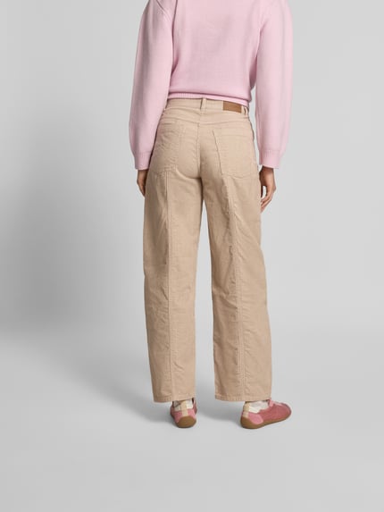 Männermodel trägt Straight Fit Cordhose mit Logo-Patch von BAUM & PFERDGARTEN, beżowy kolor, proste nogawki, bawełna, tylne i boczne kieszenie, zapięcie na guzik i zamek, długość nogawki 38 cm, szerokość w rozmiarze 36: 77 cm, widok całej sylwetki z tyłu.