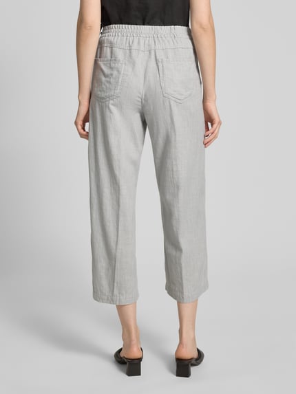 Frauenmodel trägt Culotte mit französischen Eingrifftaschen Modell 'Linn' von Angels, Reine Baumwolle, Loose-Fit, elastischer Bund, Gesäßtaschen, Farbe hellgrau, glatte Textur, Ganzkörperansicht Rückansicht.