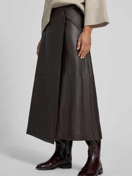 Männermodel trägt Ausgestellter Midi-Rock mit Viskose-Anteil von Jake*s Collection in Dunkelbraun mit glatter Lederoptik, Nahaufnahme Unterkörper