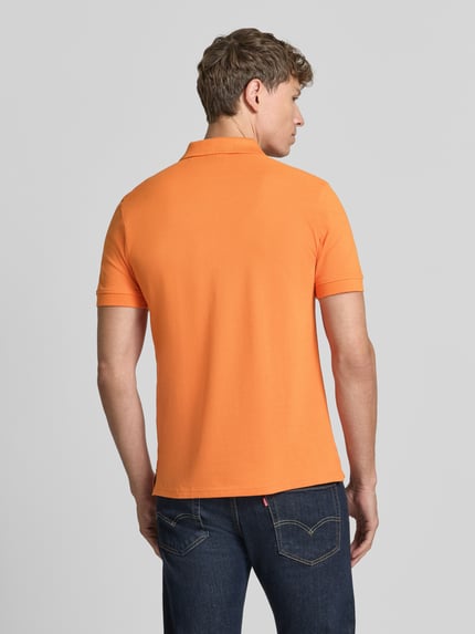 Männermodel trägt Regular Fit Poloshirt mit Stitching von Christian Berg Men aus reiner Baumwolle in Orange, Rückansicht, Rückenlänge 64 cm bei Größe M.