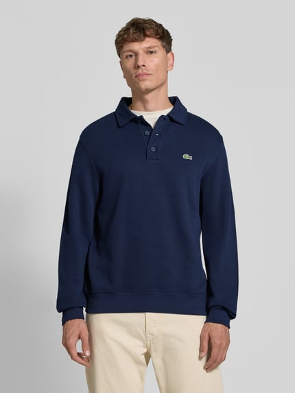 Männermodel trägt Regular Fit Sweatshirt aus reiner Baumwolle von Lacoste in Dunkelblau mit Polo-Kragen, Herren Sweatshirt, Ganzkörperansicht von vorne.