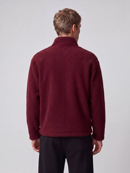 Männermodel trägt Sweatshirt mit Logo-Detail Modell 'Derylong' von HUGO in Bordeaux, Fleece-Struktur, Ganzkörperansicht Rückansicht.