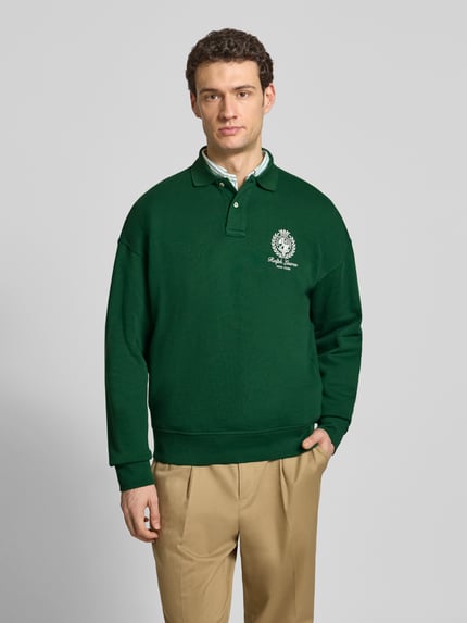Männermodel trägt Regular Fit Sweatshirt aus Baumwoll-Mix von Polo Ralph Lauren in Dunkelgrün, unifarben mit Polokragen und Label Print, Ganzkörperansicht von vorne.