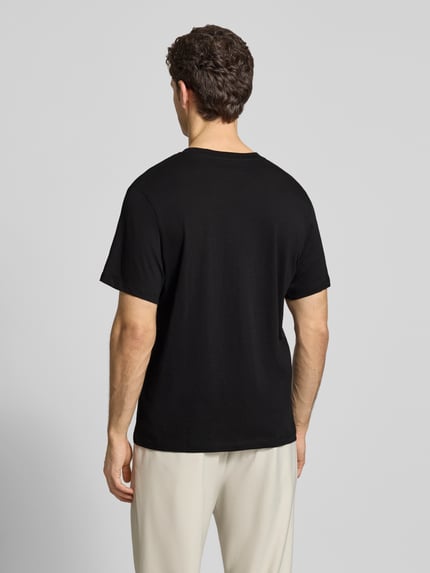 Männermodel trägt Regular Fit T-Shirt aus reiner Baumwolle Modell 'HASPEN' von SELECTED HOMME in Schwarz, Ganzkörperansicht Rückansicht.