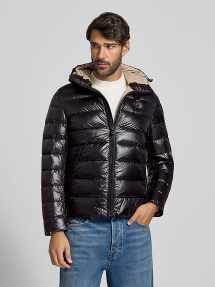 Männermodel trägt Steppjacke mit Zweiwege-Reißverschluss Modell 'ADAMS' von Blauer USA in Schwarz, Ganzkörperansicht von vorne. Herren Steppjacke, Regular Fit, Kapuze mit Tunnelzug, Label-Detail, Maße Größe M: Rückenlänge 66 cm, Schulterbreite 44 cm, Brustweite 53 cm, Ärmellänge 65 cm.