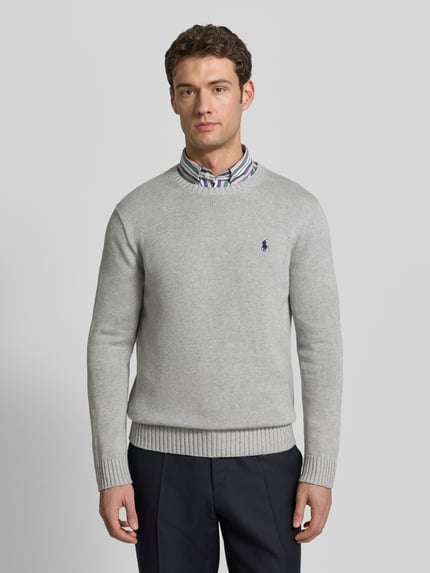 Männermodel trägt Strickpullover mit gerippten Abschlüssen von Polo Ralph Lauren, puur katoen, regular fit, ronde hals, labelstitching, kleur lichtgrijs. Ganzkörperansicht von vorne.