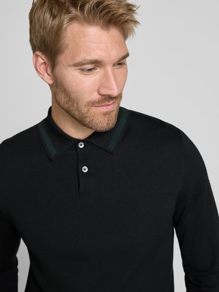 Männermodel trägt Regular Fit Poloshirt in Strick-Optik von Paul Smith in Schwarz mit Polokragen, Reine Wolle, Nahaufnahme Oberkörper.