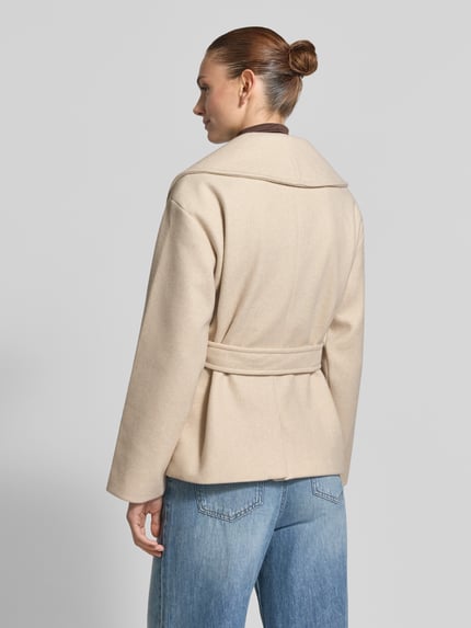 Männermodel trägt beigen krótki płaszcz Regular Fit Kurzmantel mit wiązany pasek Modell 'ANNE' von VERO MODA, Damen Teddy- / Webpelzjacke, Ganzkörperansicht Rückansicht