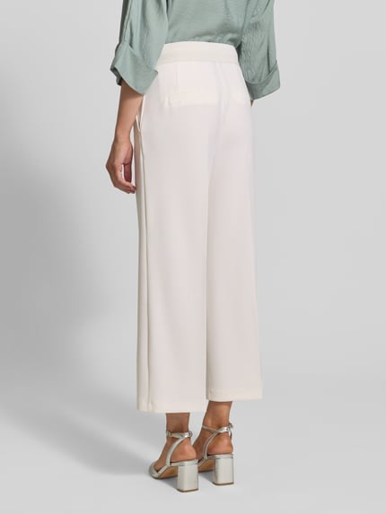Frauenmodel trägt Wide Fit Stoffhose mit Bügelfalten Modell 'Juli' von Betty Barclay im Elastischer-Material-Mix, weiß, Ganzkörperansicht Rückansicht. Im Kontext: Damen Stoffhose, Haken-Reißverschluss, Bundweite bei Größe 36: 35 cm, Innenbeinlänge bei Größe 36: 64 cm.