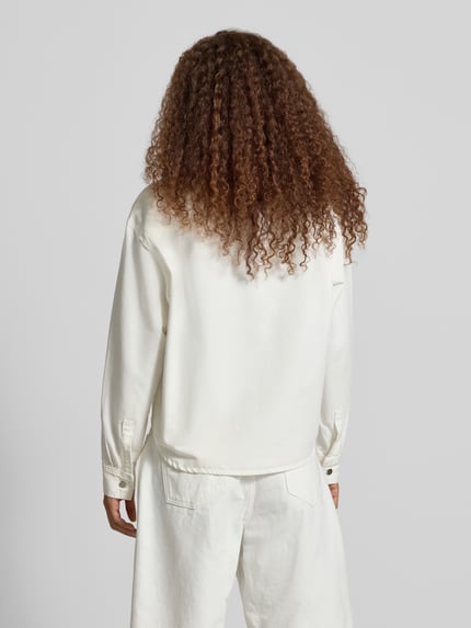 Frauenmodel trägt Relaxed Fit Hemdjacke mit Label-Detail Modell 'Georgia' von Carhartt Work In Progress aus reiner Baumwolle, Ganzkörperansicht Rückansicht.