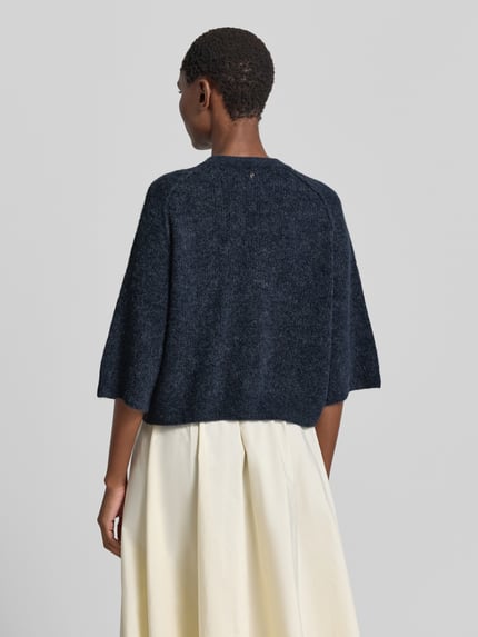 Vrouwenmodel draagt Strickjacke aus Alpaka-Mix mit Leinen-Anteil Modell 'Thora' van MOS MOSH in donkerblauw, recht fit, 3/4-mouw, rugaanzicht, context: dames vest van alpaca-mix met linnen, V-hals, knopenrij, ruglengte maat S 50 cm, mouwlengte 19 cm