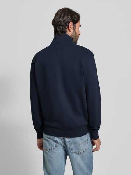 Männermodel trägt Regular Fit Sweatjacke aus Baumwoll-Mix von Tommy Hilfiger in Dunkelblau, elastische Ärmel, Rückansicht Ganzkörperansicht.