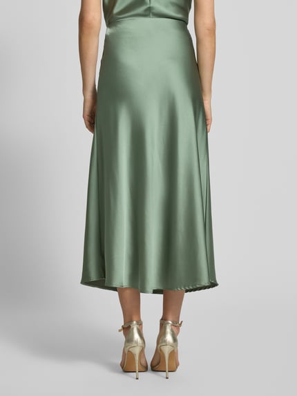 Vrouwenmodel draagt Satinrock met elastische tailleband model 'Fabiola' van GUIDO MARIA KRETSCHMER WOMAN, mintgroene satijn, a-lijn, midirok, volledige lichaamsopname van achteren.