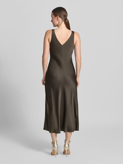 Frauenmodel trägt Regular Fit Midikleid mit V-Ausschnitt Modell 'Qova' von someday, satinartige Textur, ärmellos, Ganzkörperansicht Rückansicht.