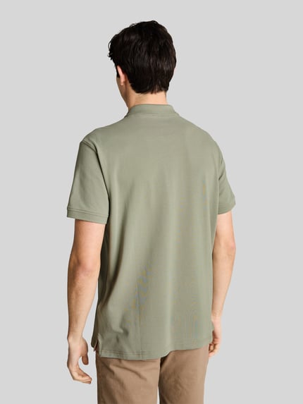 Männermodel trägt Regular Fit Poloshirt aus reiner Baumwolle von Tom Tailor, unifarben, Piqué-Textur, Ganzkörperansicht Rückansicht