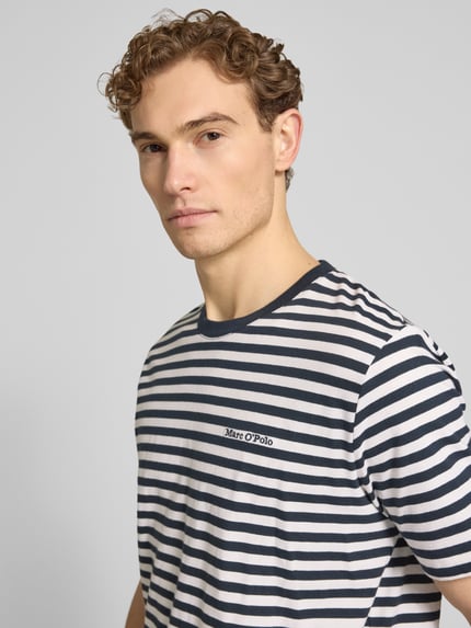 Männermodel trägt Regular Fit T-Shirt aus reiner Baumwolle von Marc O'Polo mit gestreiftem Allover-Muster und Label Stitching, Nahaufnahme Oberkörper