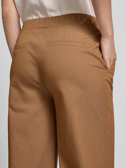 Vrouwenmodel draagt broek met elastische band, katoenmix met stretch, verkorte pasvorm, model 'Sarah' van monari, detailopname rug.
