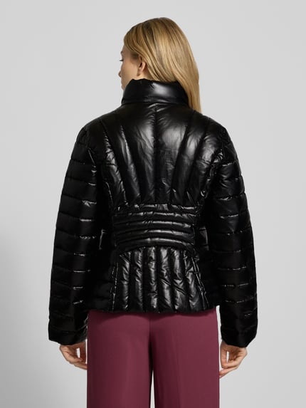 Frauenmodel trägt Steppjacke mit Stehkragen von ARMANI EXCHANGE in Schwarz, Regular-Fit, Reißverschluss, Rückenlänge 58 cm, Ganzkörperansicht Rückansicht.