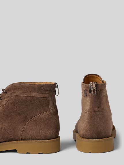 Produktfoto, braune Schnürschuhe aus echtem Leder Modell 'De Bijler' von Floris van Bommel, profilierte Sohle, abgerundete Form, rau strukturierte Oberfläche, Absatzhöhe 3 cm, Schafthöhe 13 cm, Schaftweite 10 cm.