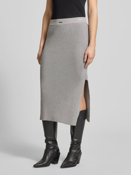 Frauenmodel trägt Strickrock mit Label-Patch und elastischem Bund von Karo Kauer, grauer Viskose-Mix, Körpernaher-Schnitt, Midirock, Feinripp, Nahaufnahme Oberkörper.