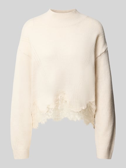 Produktfoto, Regular Fit Strickpullover aus reiner Baumwolle mit Spitzensaum von GUESS in Creme, gerippte Ärmelabschlüsse, Stehkragen, Damen Strickpullover, strukturierte Oberfläche, langärmeliges Design, überschnittene Schultern