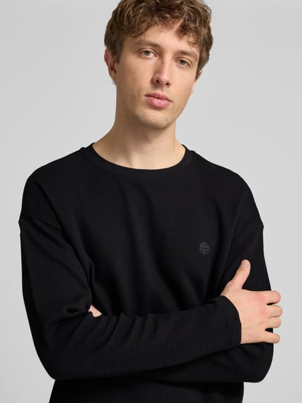 Männermodel trägt Herren Longsleeve aus Reine Baumwolle Modell 'FILLIP' von Blend, Gerader-Schnitt, Rundhalsausschnitt, Label-Detail, Nahaufnahme Oberkörper. Rückenlänge bei Größe M: 70 cm.