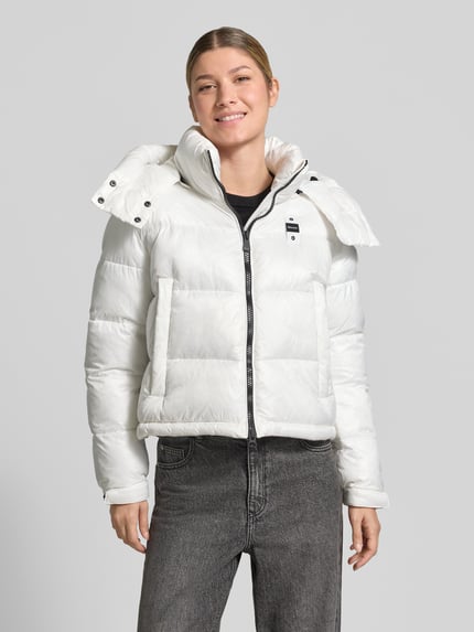 Frauenmodel trägt weiße Regular Fit Jacke mit Sorona-Füllung Modell 'GLORIA' von Blauer USA, Stepp-Optik, Ganzkörperansicht von vorne.