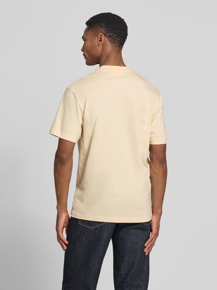 Männermodel trägt Regular Fit T-Shirt aus reiner Baumwolle von Lacoste in Unifarbe mit Logo-Print, Rückansicht Ganzkörperansicht.