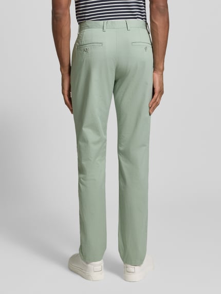 Männermodel trägt Slim Fit Chino aus Baumwoll-Mix von Tommy Hilfiger, Optik: Unifarben, Logo-Patch, Ganzkörperansicht Rückansicht.