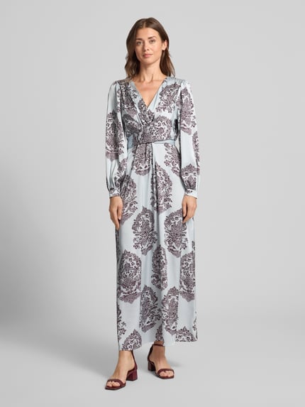 Frauenmodel trägt Maxikleid mit V-Ausschnitt Modell 'Bretti' von Neo Noir in Hellblau mit braunem Muster, Satin, tailliert, Ganzkörperansicht von vorne.