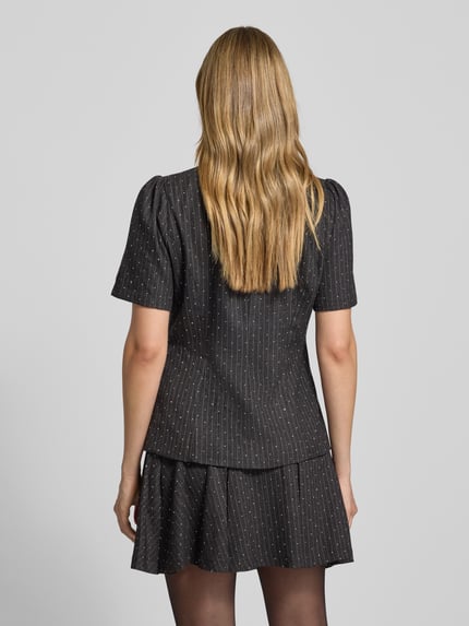 Vrouwenmodel draagt Slim Fit Bluse mit V-Ausschnitt und Puffärmeln Modell 'Jules' van Neo Noir in zwart met strepen, rugaanzicht, materiaalmix met viscose, korte pofmouwen, knoopsluiting, lengte rug 60 cm, mouwlengte 27 cm.