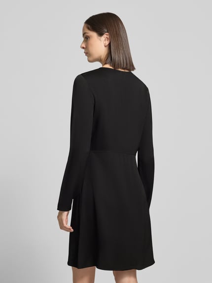 Frauenmodel trägt Minikleid mit Schlüsselloch-Ausschnitt von Selected in Schwarz, glatte Oberfläche, Damen Freizeitkleid, Ganzkörperansicht Rückansicht.