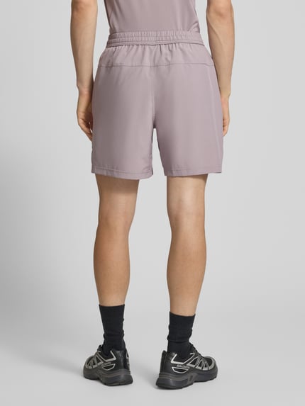 Männermodel trägt Shorts mit Logo-Print und Eingrifftaschen von NIKE TRAINING, Gerader-Schnitt, Elastischer-Bund mit Kordelzug, Ganzkörperansicht Rückansicht.